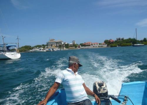 a man on a boat in the water at Villa Los Almendros - 2 private pools tennis pickle ball in Baní