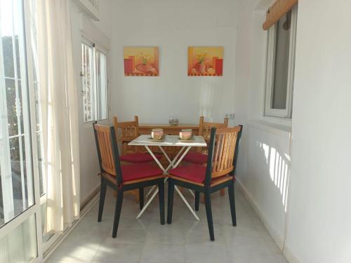 a dining room table with two chairs and a table with cups on it at Charming Bungalow in Torrevieja Near La Mata Natural Park in La Mata