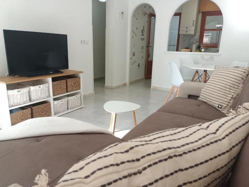a living room with a couch and a tv at Charming Bungalow in Torrevieja Near La Mata Natural Park in La Mata