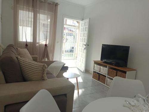 a living room with a couch and a flat screen tv at Charming Bungalow in Torrevieja Near La Mata Natural Park in La Mata