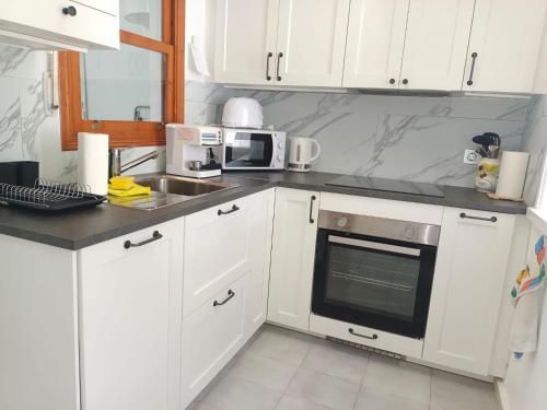 a kitchen with white cabinets and a sink at Charming Bungalow in Torrevieja Near La Mata Natural Park in La Mata