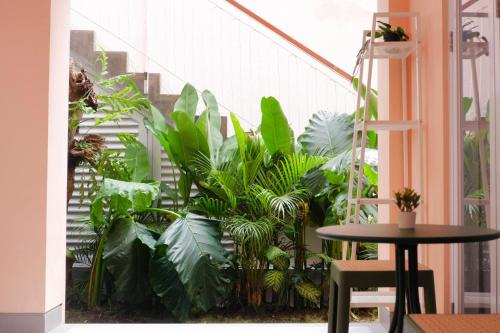 a balcony with green plants and a table and a staircase at Ponder Bali Canggu in Canggu