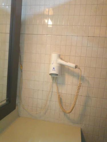 a hair dryer on the wall of a bathroom at All Seasons Hotel - Executive in Owerri
