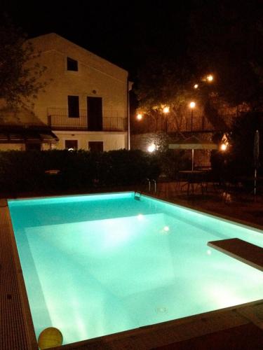 a blue swimming pool at night with a building at Il Casalino in Maratea