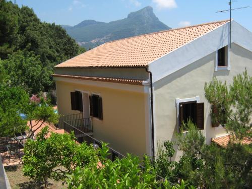 a small white house with a mountain in the background at Il Casalino in Maratea