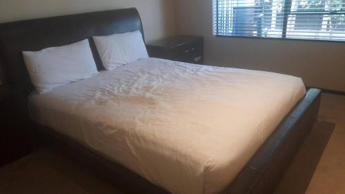 a bed with white sheets and pillows in a bedroom at Quiet, Very Specious Apartment In Dainfern in Johannesburg