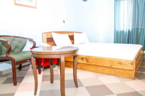 a bedroom with a bed and a table and a chair at Hotel Bariba Playa relaxation experience in Cotonou