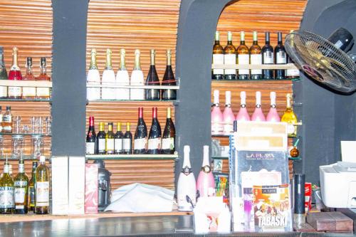 a bar with a lot of bottles of wine at Hotel Bariba Playa relaxation experience in Cotonou