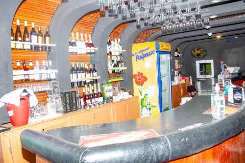 a bar with a counter with bottles of alcohol at Hotel Bariba Playa relaxation experience in Cotonou