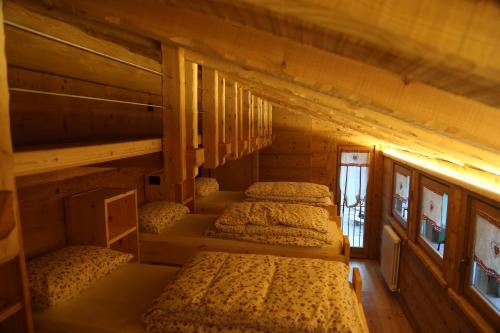 una camera con 4 letti a castello in una cabina di Rifugio Luna Nascente a San Martino