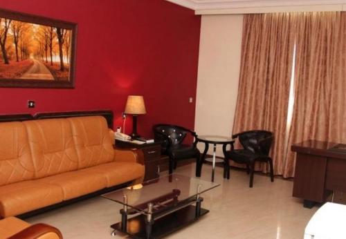 a living room with a couch and a table and chairs at Agura Hotel - Standard King in Abuja