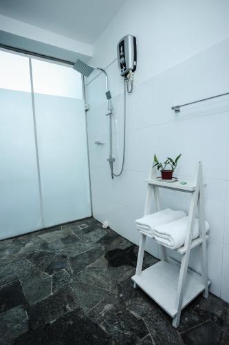 a bathroom with a shower and a white stool at Range Kandy in Kandy