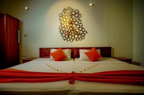 a bedroom with a large bed with orange pillows at Range Kandy in Kandy