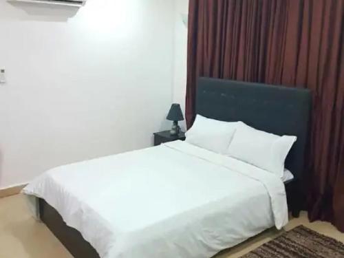 a bedroom with a white bed with a blue headboard at Goosepen 3 Bedrooms Apartment in Lagos