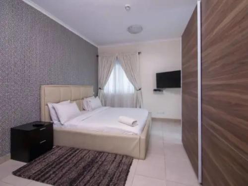 a bedroom with a white bed and a window at Goosepen 3 Bedrooms Apartment in Lagos