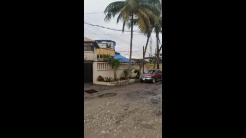 a parking lot with a car and palm trees at Divine Fountain Hotel - Deluxe in Lagos