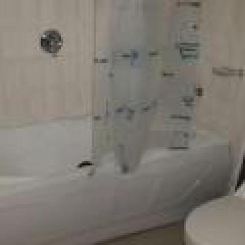 a bathroom with a white tub and a toilet at Habitat Hotel and Suites -Standard in Port Harcourt