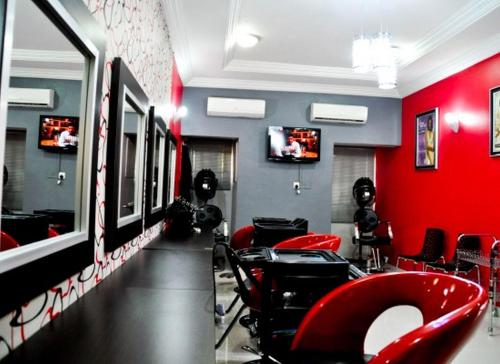 a hair salon with red walls and red chairs at Auris Court - Economy in Jabi