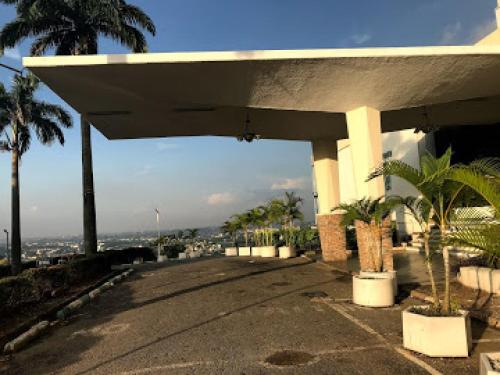 a white building with palm trees in front of it at Premier Hotel-ibadan in Ibadan