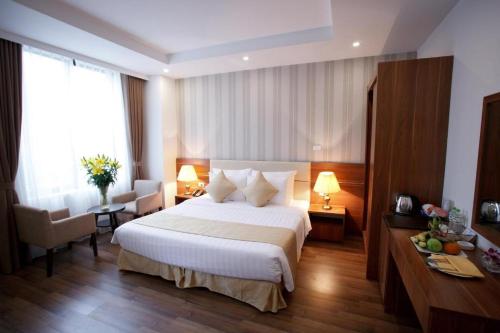a hotel room with a large bed and a desk at The Embassy Hotel Hanoi in Hanoi