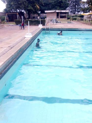 a group of people swimming in a swimming pool at Premier Hotel-ibadan in Ibadan