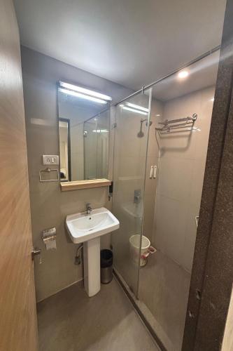 a bathroom with a sink and a shower at Hotel Concord Galaxy in Mumbai