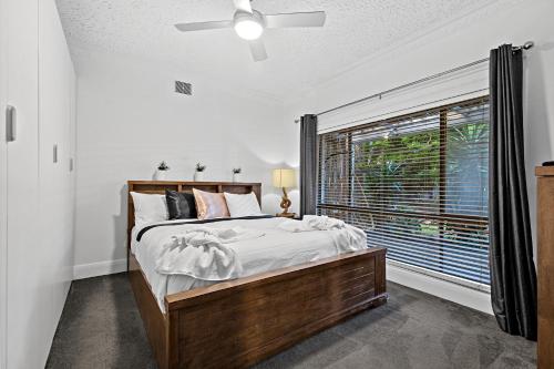 a bedroom with a bed and a large window at Aspendale Beach House in Aspendale