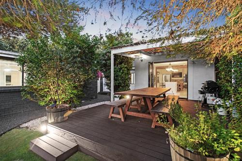 a wooden deck with a picnic table in a backyard at Aspendale Beach House in Aspendale