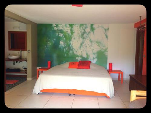ein Schlafzimmer mit einem Bett und einem Wandgemälde in der Unterkunft Aluna Ecolodge in Petit-Bourg