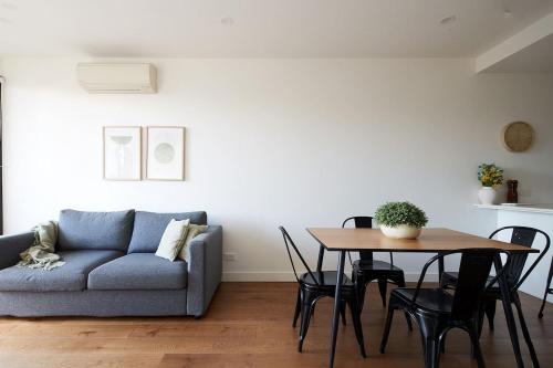 吉朗Urban Drift - Cosy Balcony Nook near Waterfront的客厅里有一张沙发和一张桌子。