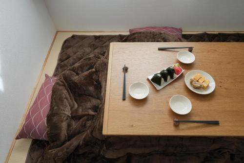 a table with two plates of food on a bed at パーパスリゾート 越後湯沢 蔵 in Yuzawa