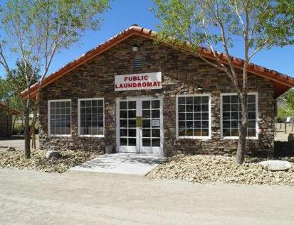 a brick building with a sign that reads little enchantment at Death Valley Inn in Beatty