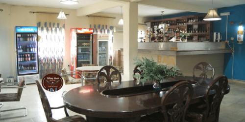 a restaurant with a table and chairs and a bar at Tiffany Hotels and Towers in Imogwu-Agwa