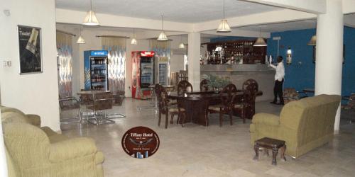 a man standing at a bar in a living room at Tiffany Hotels and Towers in Imogwu-Agwa
