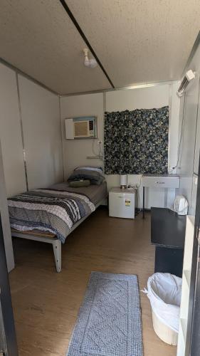 Habitación pequeña con 2 camas y alfombra en Widgiemooltha Caravan Park, en Widgiemooltha