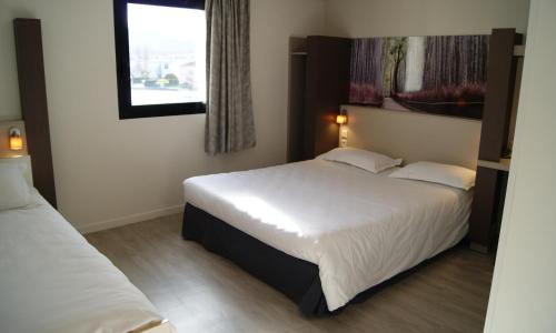 a hotel room with two beds and a window at The Originals City, Hôtel Clermont-Ferrand Sud Aubière in Aubière