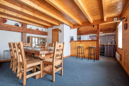 une salle à manger avec une table et des chaises en bois dans l'établissement Chalet La Chapelle aux pieds des pistes, à Chamonix-Mont-Blanc