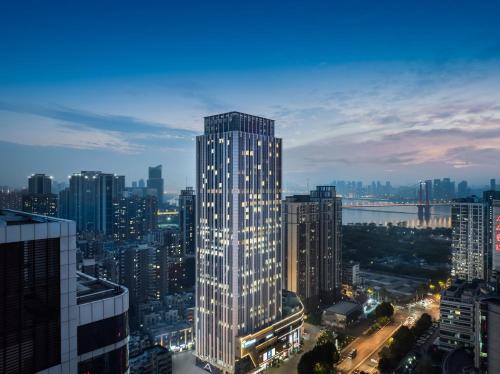 武漢市にあるAtour Hotel Wuhan Yellow Crane Tower Shouyi Plazaの夜の街の高層ビル