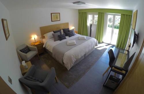 Schlafzimmer mit einem großen Bett und grünen Vorhängen in der Unterkunft Les Hortensias in Lantosque