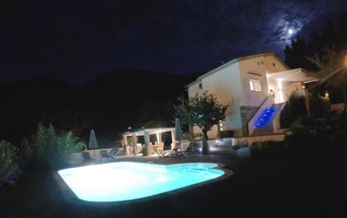 une piscine devant une maison la nuit dans l'établissement Les Hortensias, à Lantosque