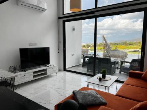a living room with a flat screen tv and a couch at Modern and comfortable studio apartment in Ayios Nikolaos
