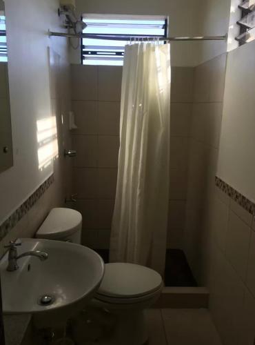 a bathroom with a toilet and a sink and a shower at Natos Residences - St Francis in Bacolod