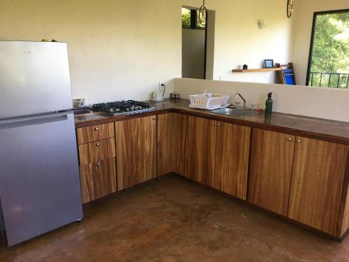 a kitchen with wooden cabinets and a refrigerator at Departamento Completo, Playa Paradisiaca, in Cuatunalco