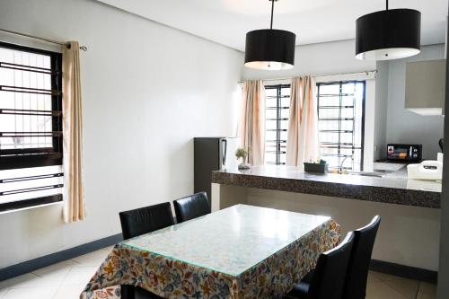 a kitchen and dining room with a table and chairs at Natos Residences - St Francis in Bacolod