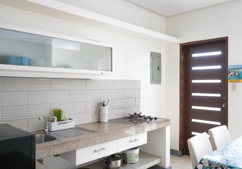 a kitchen with a sink and a counter top at Natos Residences - St Francis in Bacolod