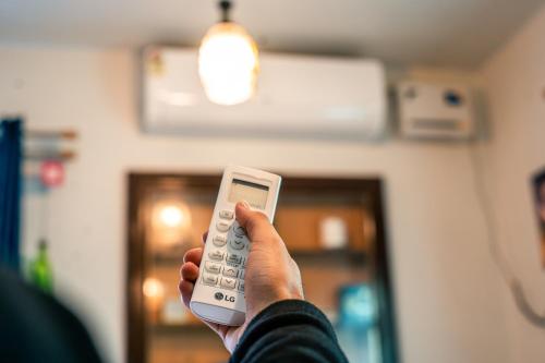 a person holding a remote control in their hand at Grand Aurora Retreat in Srinagar