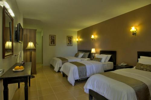 a room with three beds in a hotel at Hanan Hotel Tagaytay - Formerly Tagaytay Wingate Manor in Tagaytay