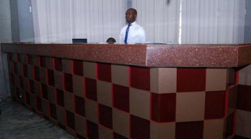 a man standing behind a counter in a room at Royal Park Hotel Suite - Standard in Asaba