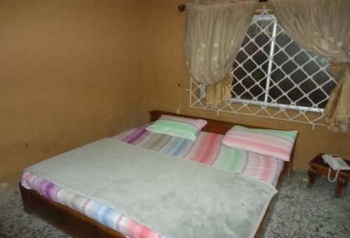a small bedroom with a bed with a window at Royal Park Hotel Suite - Standard in Asaba