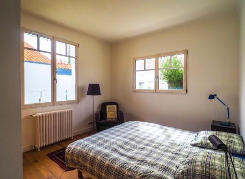 Un dormitorio con una cama y dos ventanas. en Villa Golf Biarritz, en Anglet